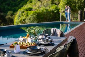a table with food on it next to a pool at Okoro Villa in Nelson