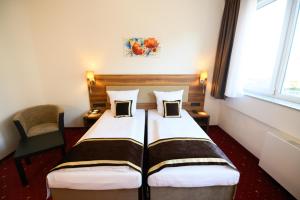 um quarto de hotel com uma cama e uma cadeira em Hotel Luna em Offenbach