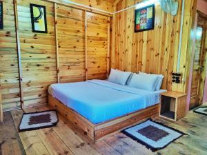 - une chambre avec un lit dans une cabane en rondins dans l'établissement Mid Conifer Resort and Cottages, à Dalhousie