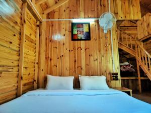 - une chambre avec un lit dans un mur en bois dans l'établissement Mid Conifer Resort and Cottages, à Dalhousie