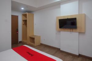 Una televisión o centro de entretenimiento en RedDoorz Apartment near Exit Toll Colomadu