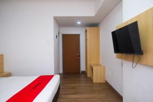 Una televisión o centro de entretenimiento en RedDoorz Apartment near Exit Toll Colomadu