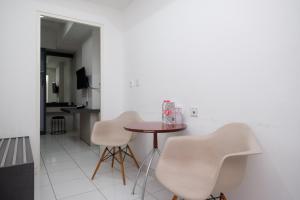comedor con mesa y 2 sillas blancas en RedDoorz Apartment near Exit Toll Colomadu, en Solo