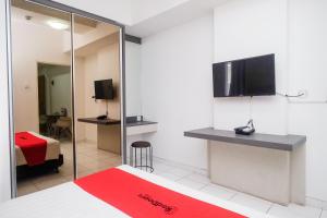 Una televisión o centro de entretenimiento en RedDoorz Apartment near Exit Toll Colomadu