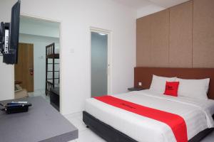 a bedroom with a large bed with red pillows at RedDoorz Apartment near Exit Toll Colomadu in Solo