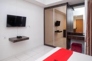 una camera con letto e TV a parete di RedDoorz Apartment near Exit Toll Colomadu a Solo