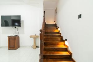 uma escada com degraus de madeira num quarto com uma televisão em Omega Villa em Galle