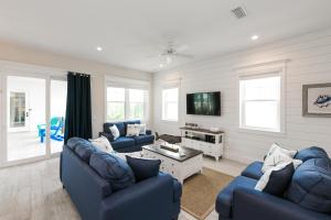 a living room with two blue couches and a tv at Blue Marlin in Anna Maria