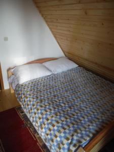 a bed with two pillows in a room at Holiday Home Villa Snježina in Vlasic