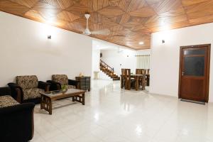 a living room with couches and chairs and a table at Omega Villa in Galle