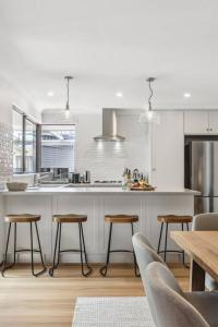 a kitchen with a counter and stools in it at Sea La Vie ~ Pet Friendly Coastal Chic Broadwater Retreat in Broadwater