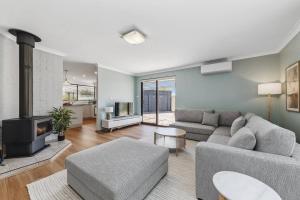 a living room with a couch and a fireplace at Sea La Vie ~ Pet Friendly Coastal Chic Broadwater Retreat in Broadwater