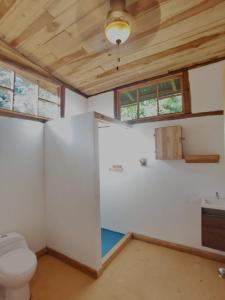 y baño con aseo y lavamanos. en Rusteak Living Retreat in natural and peaceful setting in Canafistula, en Cañafístula