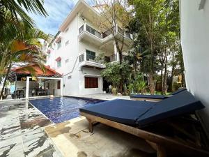 a swimming pool in front of a house with a pool table at The One by Nika in Siem Reap