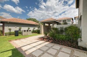 a house with a walkway in front of a yard at Place to remember in Sandton