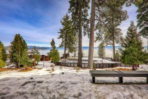 un banco de parque sentado en la arena frente a los árboles en 4BD Lakeside Retreat with Views, en Tahoe City