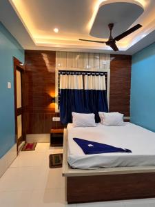 um quarto com uma cama com uma parede azul em Hotel Holiday Home em Digha