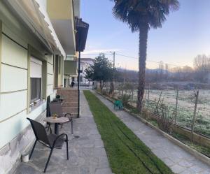 un patio con una mesa, sillas y una palmera en Ο ΦΟΙΝΙΚΑΣ ΣΤΗΝ ΚΑΣΤΟΡΙΑ en Kastoria