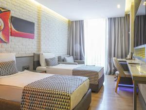 a hotel room with two beds and a couch at Laren Family Hotel & Spa - Boutique Class in Antalya