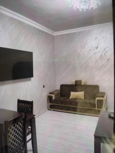 uma sala de estar com um sofá e uma televisão de ecrã plano em Argavand home em Yerevan