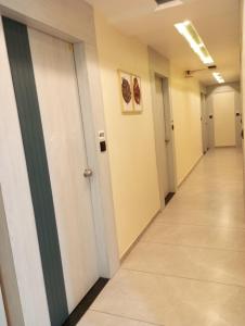 a hallway of an office building with white doors and a hallwayngth at HOTEL R K VILLA in Ahmedabad