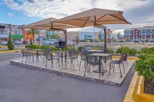 a group of tables and chairs under an umbrella at City Express Junior by Marriott Juarez Consulado in Ciudad Juárez