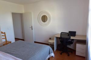 a bedroom with a desk and a bed and a chair at Rita's house in Ponta Delgada