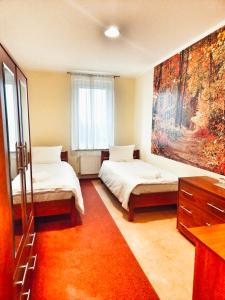 ein Schlafzimmer mit 2 Betten und einem Wandgemälde in der Unterkunft Hotel Max in Luboń