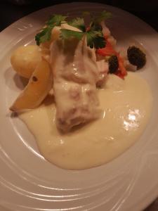un plato blanco de comida con carne y verduras en SL rum, en Estocolmo