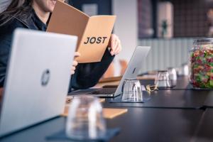 een vrouw zit aan een tafel met twee laptops bij JOST Hôtel Le Havre Centre Gare in Le Havre