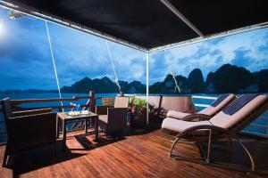una terrazza con sedie e un tavolo su una barca di Mila Cruises a Ha Long