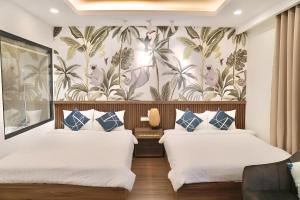 two beds in a hotel room with a wallpaper at FLC Sea Tower Condotel in Quy Nhon +95 photos