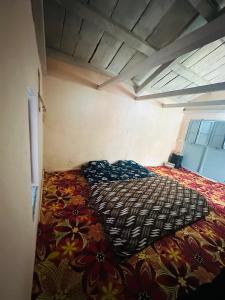a bedroom with a large bed with a colorful comforter at Deodar Village Homestay Devalsari in Mussoorie