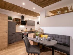 uma sala de estar e cozinha com uma mesa e um sofá em Appartement Torblick em Ellmau