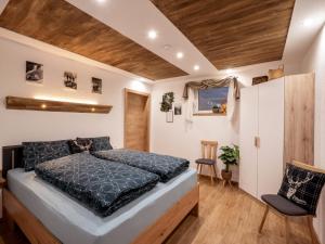 um quarto com uma cama e uma cadeira em Appartement Torblick em Ellmau