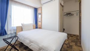 Postel nebo postele na pokoji v ubytování Toyoko Inn Yokohama-eki Nishi-guchi