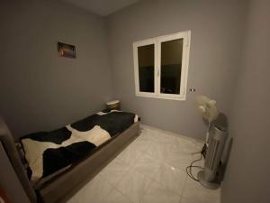 - une chambre avec un lit dans une pièce dotée d'une fenêtre dans l'établissement S+2 Corniche Nord, à Bizerte