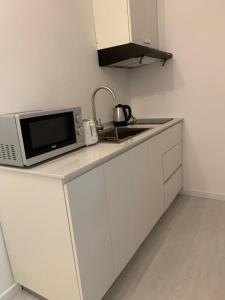 a kitchen with a microwave and a sink at Le Clos des Bains Mauritius in Blue Bay