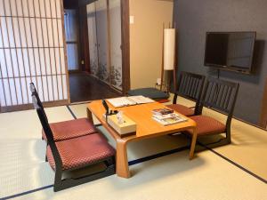 een woonkamer met een tafel en twee stoelen bij Kyoto Miyabi Inn in Kyoto