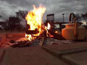 Ein Feuer brennt vor einem großen Objekt. in der Unterkunft Uakii Wilderness Bush Camp in Gobabis