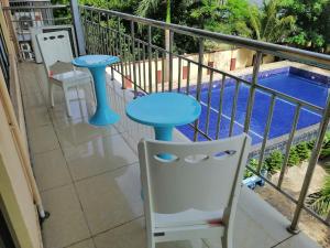 a balcony with a table and a chair and a pool at Blessie Ocean View Home in Dar es Salaam