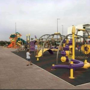 un niño parado frente a un parque infantil en Blanca Beach, en Sidi Rahal