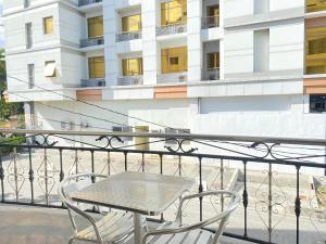 einen Tisch und Stühle auf einem Balkon mit einem Gebäude in der Unterkunft Valentino's Hotel in Angeles