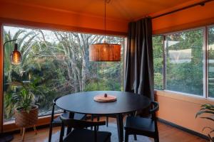 a dining room with a table and chairs in front of a window at Te Tupahipahi - The Sandspit in Nelson