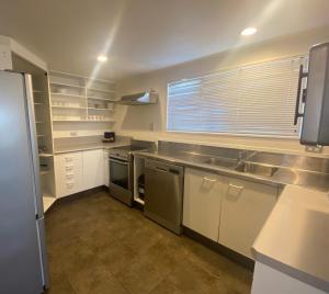 a kitchen with white cabinets and stainless steel appliances at Lakeside Taupo Motel in Taupo