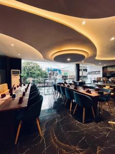 une salle à manger avec de longues tables et chaises dans l'établissement Golden Palace Hotel, à Batu Merah