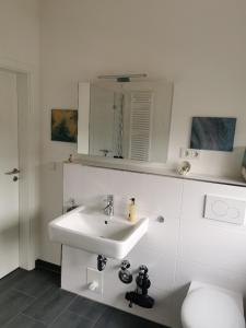 a white bathroom with a sink and a toilet at NEU! Schicke und moderne FeWo Lindenalle OG in Hanstedt