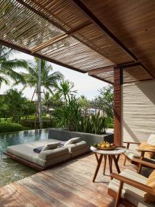 un patio con una cama, una mesa y una piscina en The Retreat, Koh Chang en Ko Chang