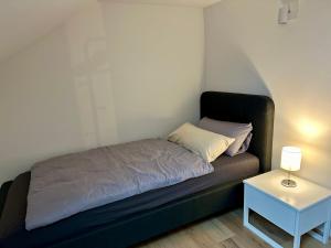 małe łóżko w pokoju ze stolikiem w obiekcie Schöne, helle Ferienwohnung in Lünen Mitte ! w mieście Lünen