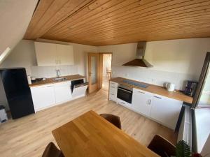 a kitchen with a wooden table and a wooden ceiling at Perfekte Auszeit im Erzgebirge in Sayda